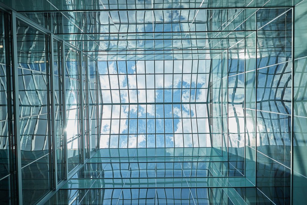 Photo of a glass ceiling wth clouds in the sky