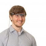 Photo of a man wearing eye-tracking technology glasses