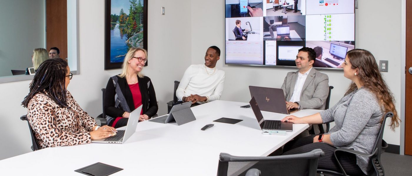 Photo of five people sitting around a board room table in a focus group room