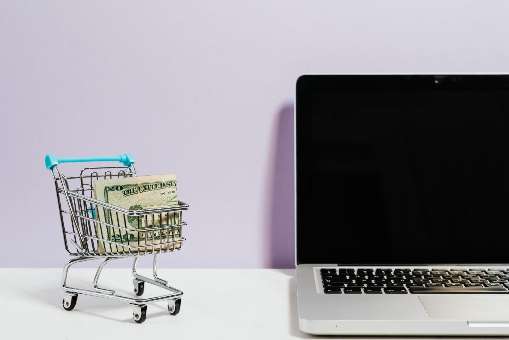 Photo of a mini shopping cart beside a computer
